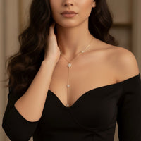 Woman wearing a delicate necklace with star-shaped pendants against a neutral background - Eternal Stars Lariat Necklace - The Songbird Collection