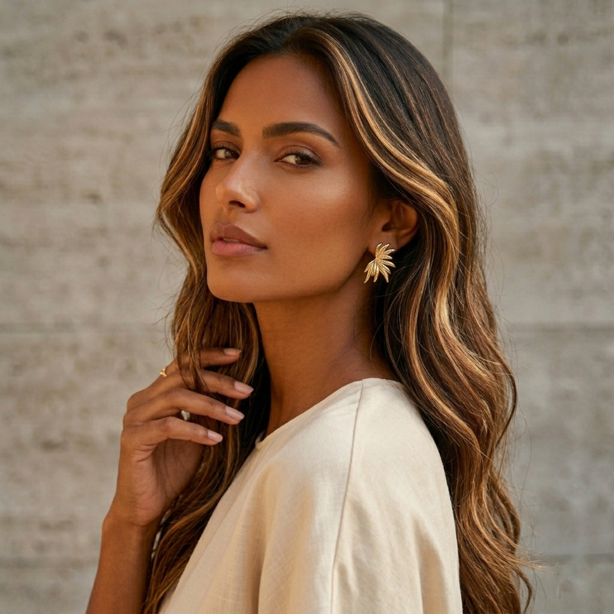 Woman with long, wavy hair wearing a white top against a neutral background - Fireworks Statement Earrings - The Songbird Collection