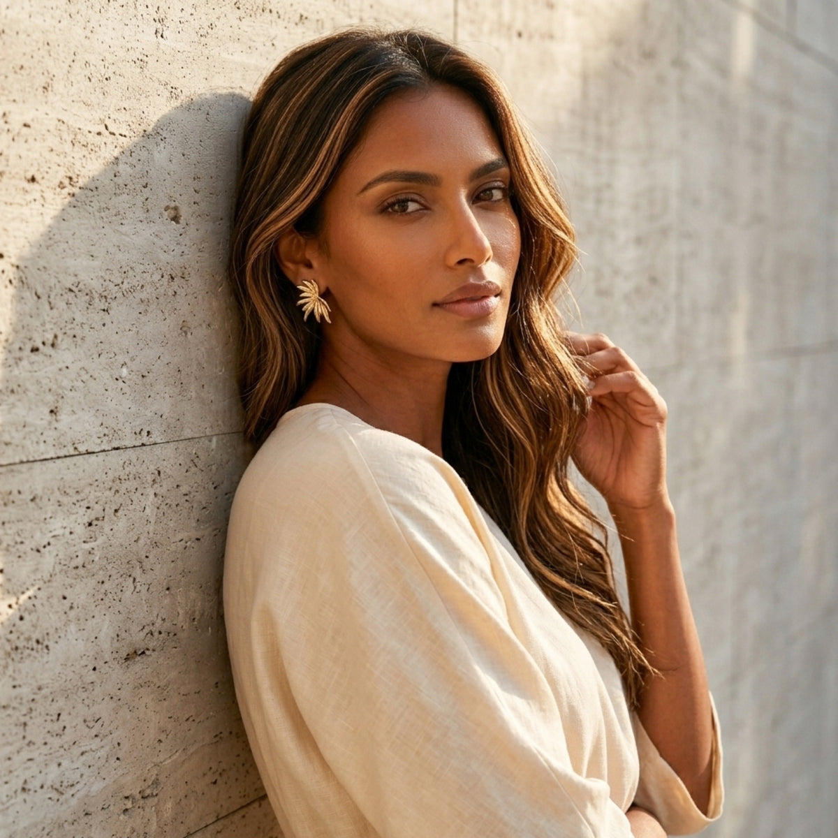 Woman in a beige outfit leaning against a textured wall - Fireworks Statement Earrings - The Songbird Collection