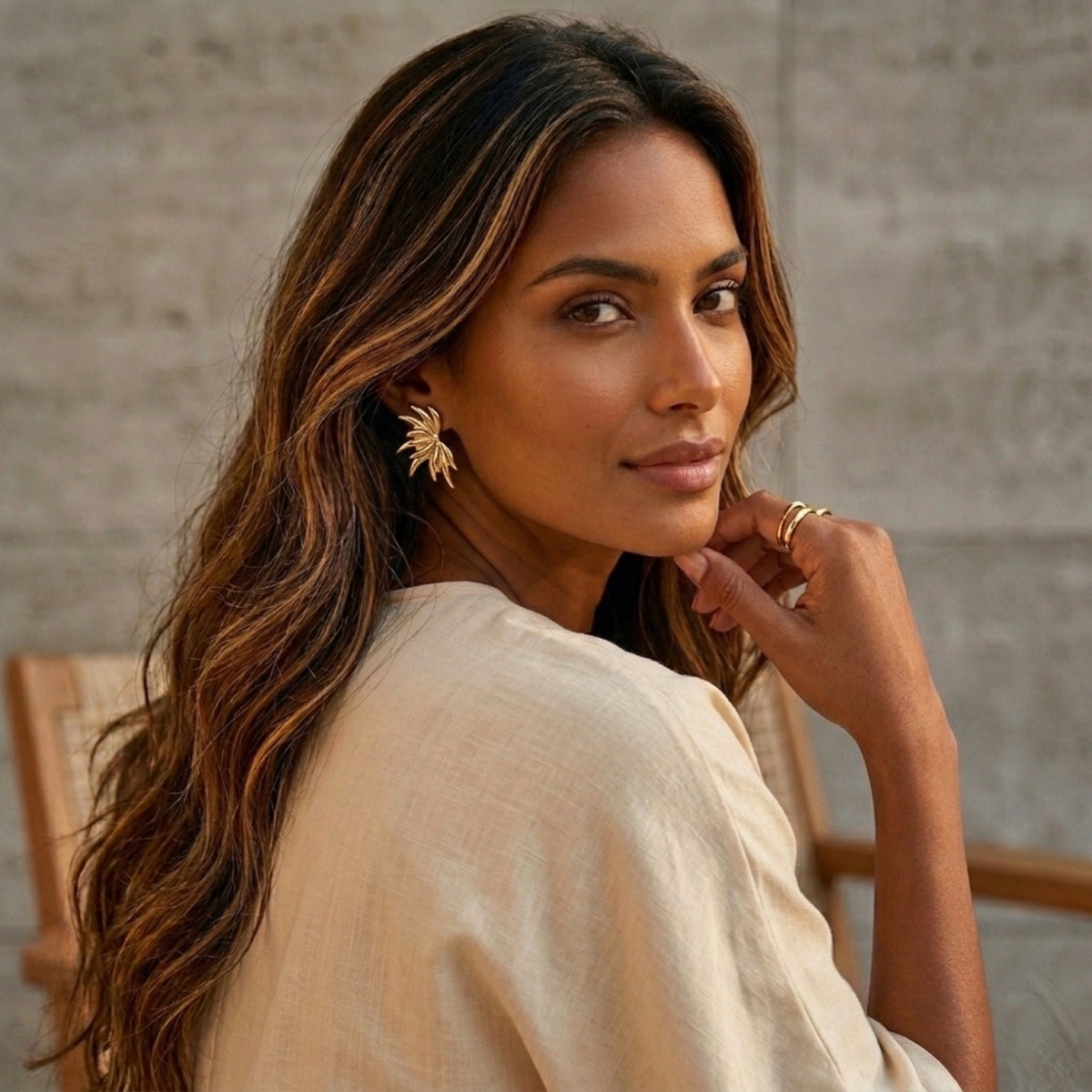 Woman with long hair and earrings sitting on a chair against a neutral background - Fireworks Statement Earrings - The Songbird Collection