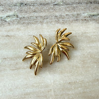 Pair of gold leaf-shaped earrings on a light stone surface -0 Fireworks Statement Earrings - The Songbird Collection