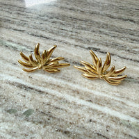 Gold leaf-shaped earrings on a marble surface - Fireworks Statement Earrings - The Songbird Collection