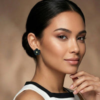 Woman wearing a black flower earring with black and white dress with a blurred background