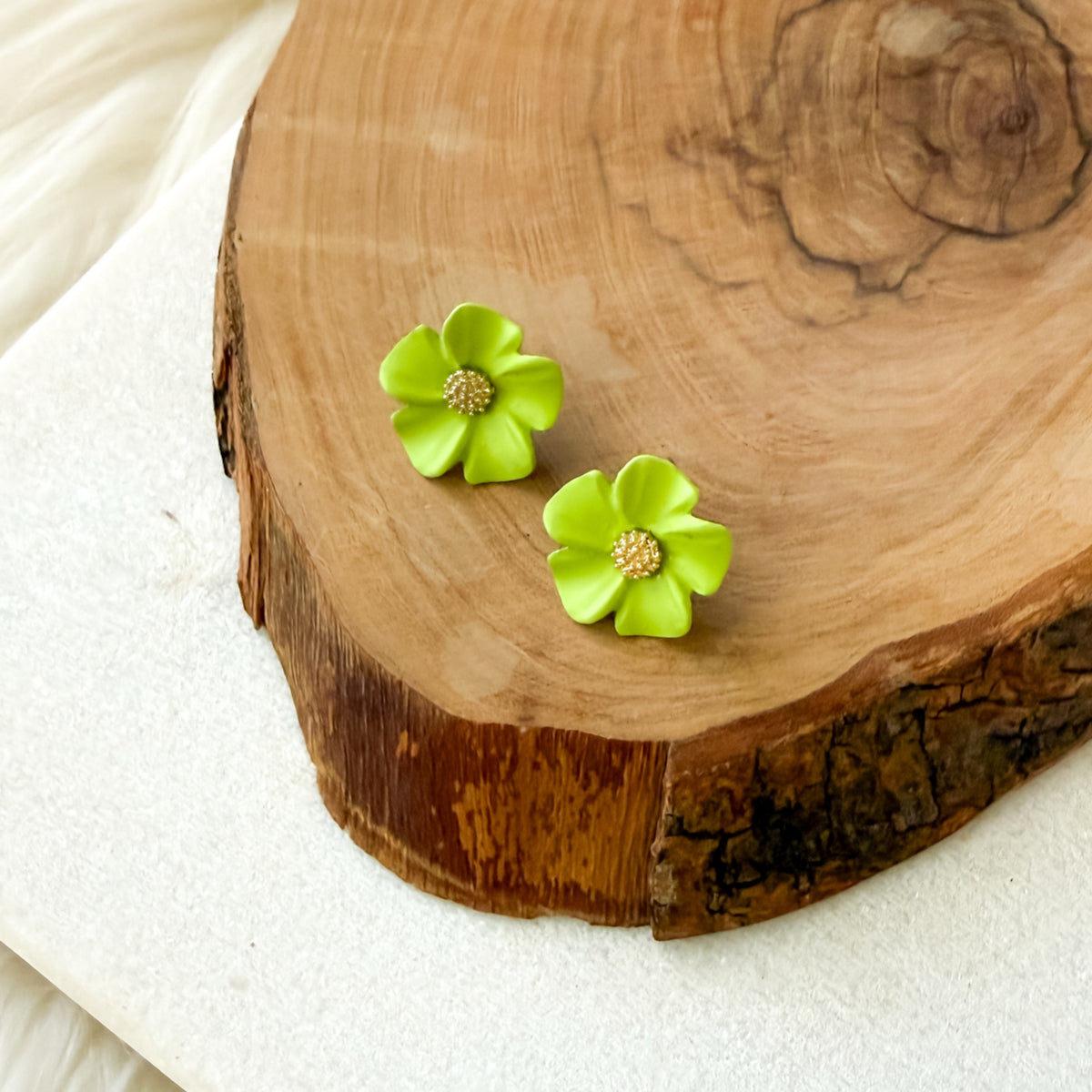 Lime Green flower-shaped earrings on a wooden surface