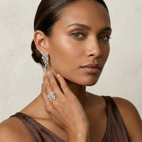 Woman wearing elegant earrings and ring against a neutral background  . Chandelier Earrings and Ring - The Songbird Collection