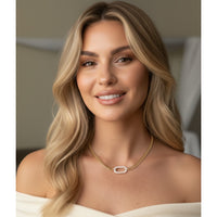 Woman wearing a gold necklace with a blurred background