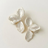Pair of white floral earrings on a light beige background  Ivory_Lotus_Statement_Earrings_-_The_Songbird_Collection