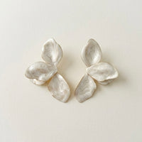 Pair of  white beige mother of pearl earrings on a light beige background  Ivory_Lotus_Statement_Earrings_-_The_Songbird_Collection