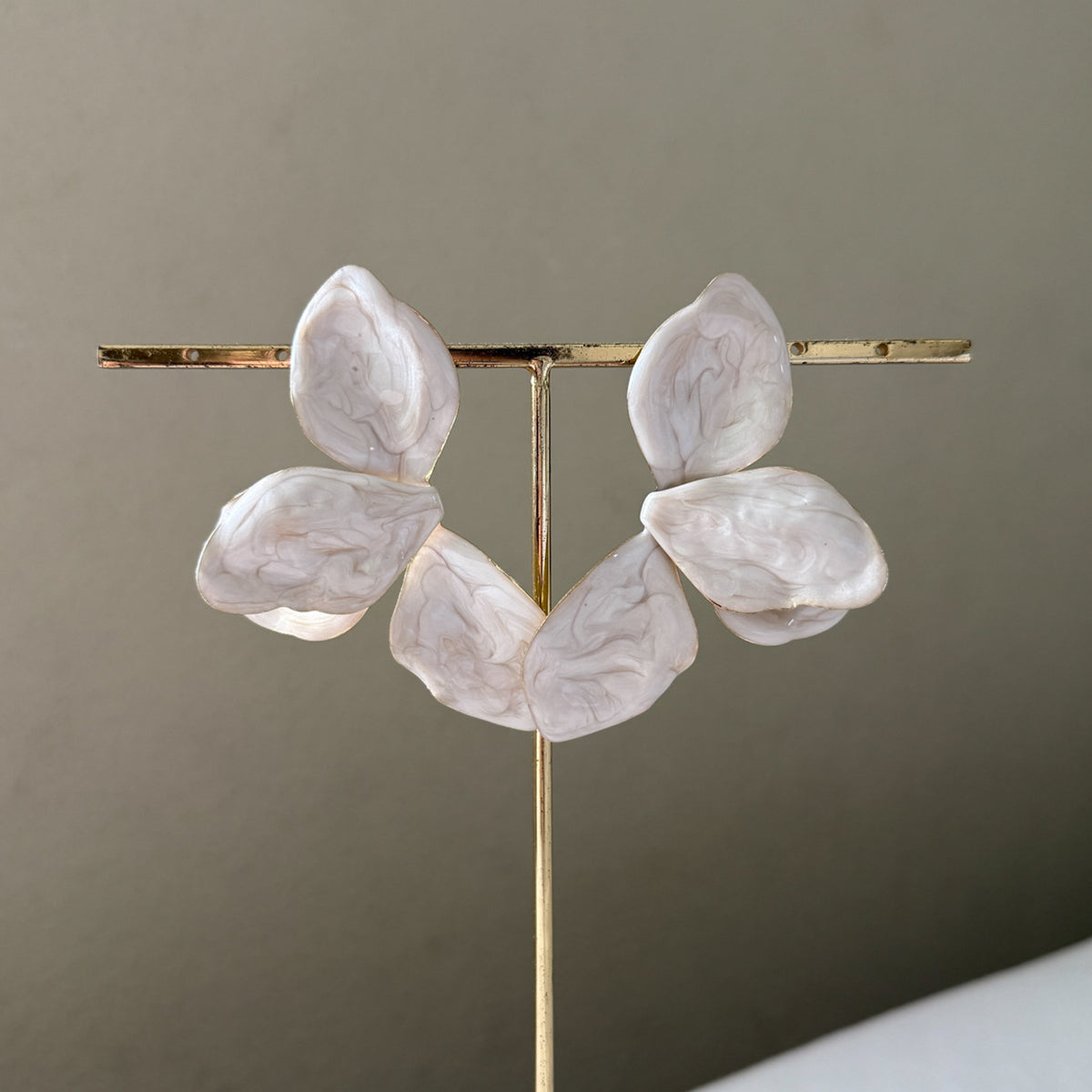 Decorative lamp with marble-like leaves on a gold stand against a neutral background  Ivory_Lotus_Statement_Earrings_-_The_Songbird_Collection