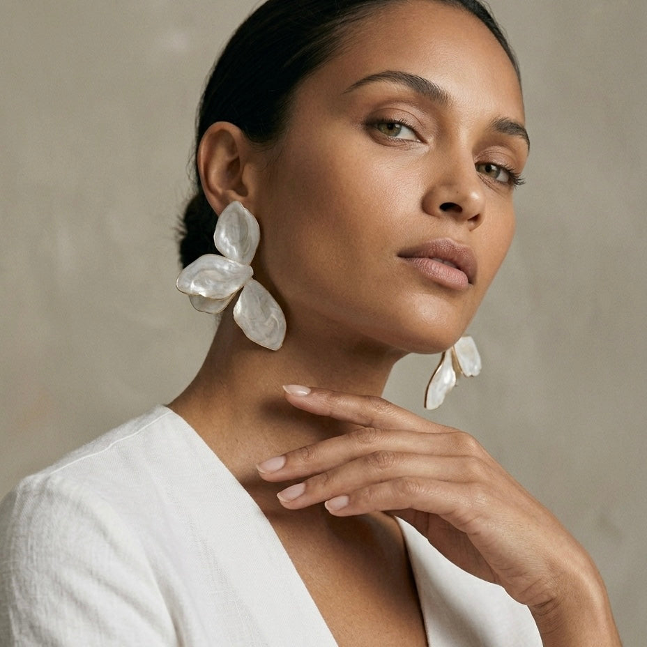 Woman wearing large white earrings against a neutral background  Ivory_Lotus_Statement_Earrings_-_The_Songbird_Collection