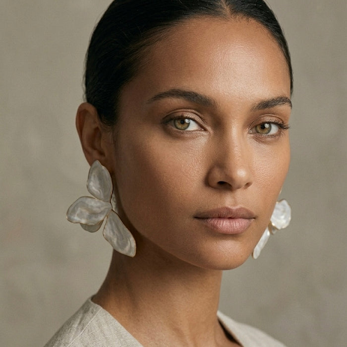 Woman wearing large white earrings against a neutral background  Ivory_Lotus_Statement_Earrings_-_The_Songbird_Collection