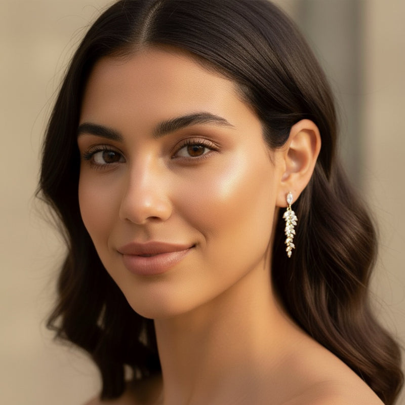 Woman wearing a delicate earring with a neutral background