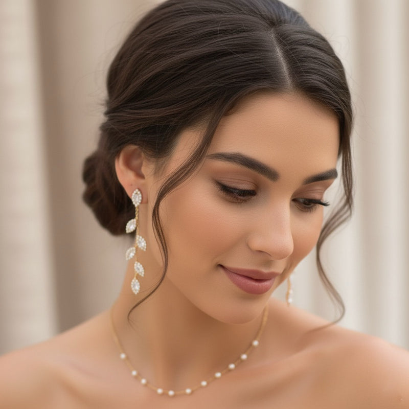 Woman wearing elegant earrings and a necklace against a neutral background