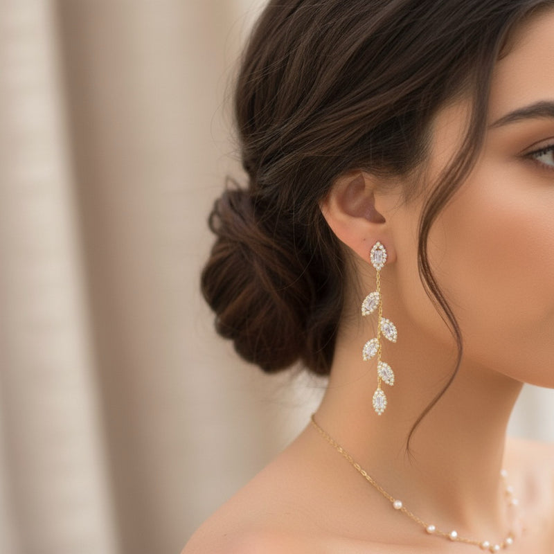 Close-up of a woman wearing diamond earrings with a neutral background