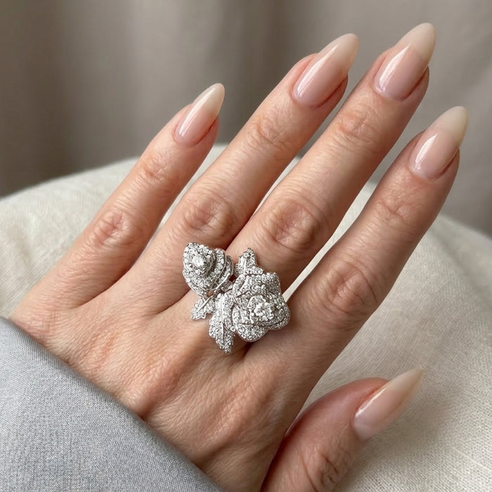 Silver ring with sparkly rose on a hand with beige nails