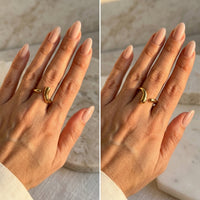 Two hands wearing a gold ring on a neutral background  Liquid Curve Ring - The Songbird Collection