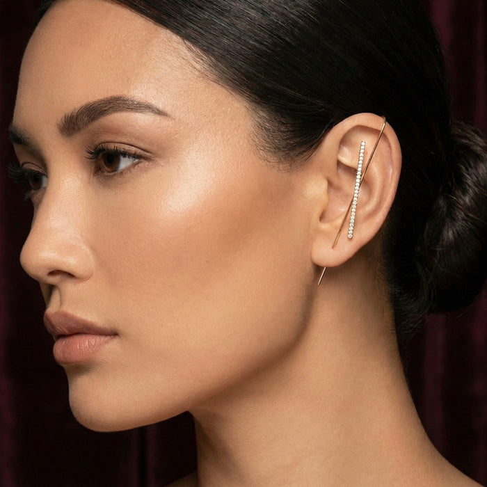 Close-up of a woman wearing a diamond studded ear hook/ear cuff/ earring with a dark background