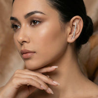 Woman wearing a silver ear cuff/ ear hook/ earring with a a bar of micropave setting of diamonds