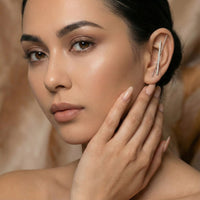 Woman wearing a silver ear cuff/ ear hook/ earring with a a bar of micropave setting of diamonds