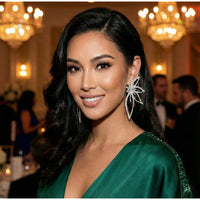 Woman in a green dress with floral earrings in a formal setting