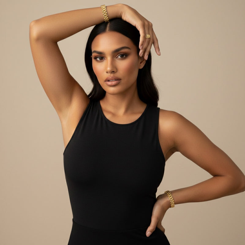 Woman wearing a black sleeveless top with gold jewelry against a beige background - Lucia Watch Link Chain Bracelet - The Songbird Collection