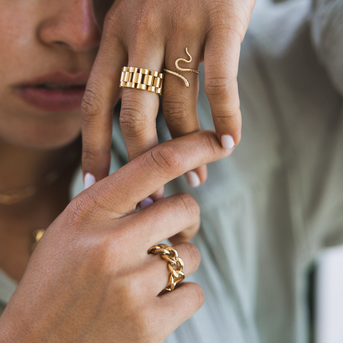 A person's hands showcasing a gold-plated chunky chain ring, with a focus on the jewelry.