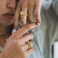 A person's hands showcasing a gold-plated chunky chain ring, with a focus on the jewelry.