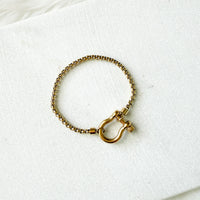 Gold bracelet with a clasp on a white background