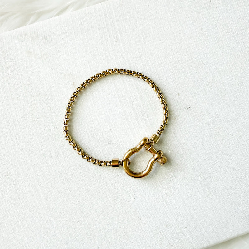 Gold bracelet with a clasp on a white background