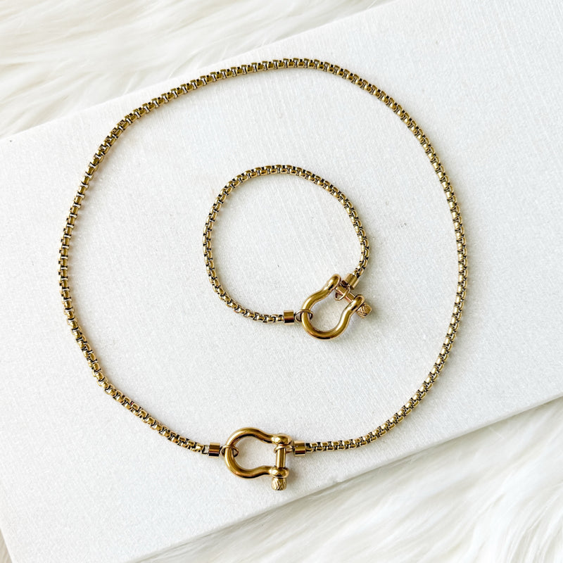 Gold chain necklace with clasp on a white surface