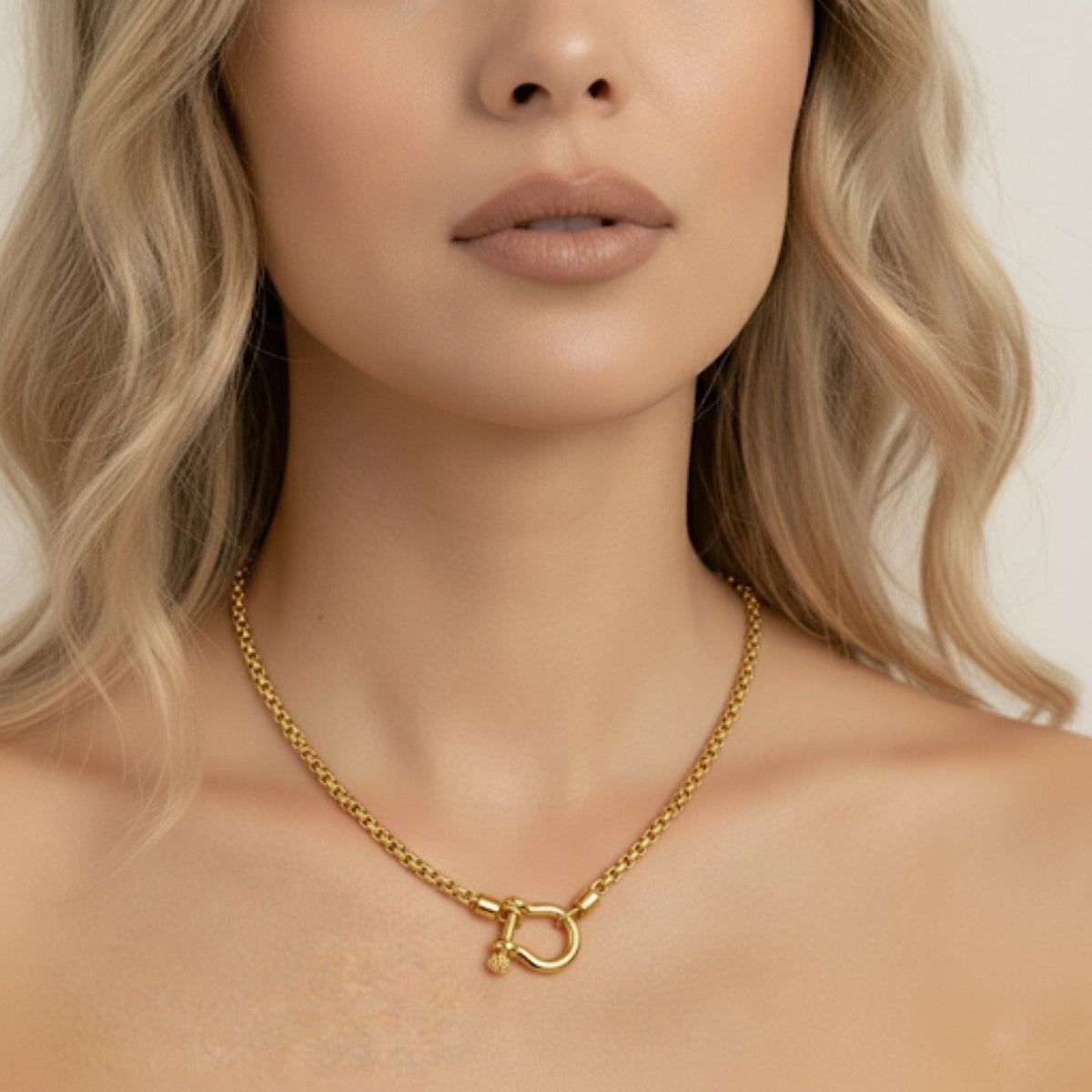Gold necklace worn by a model with a neutral background