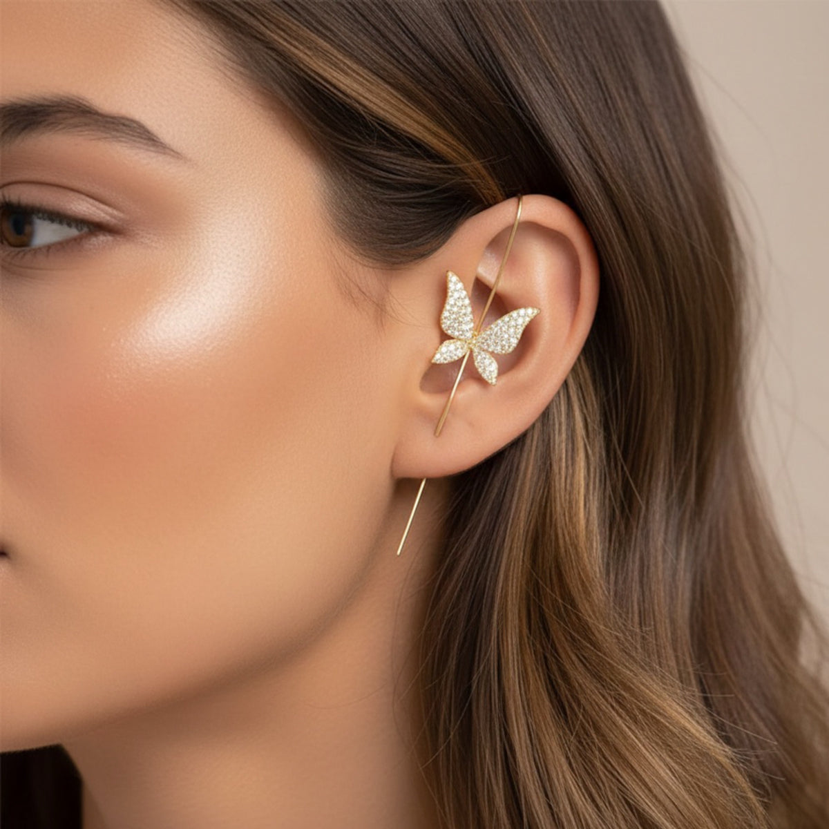 Butterfly-shaped earring worn by a model with a neutral background
