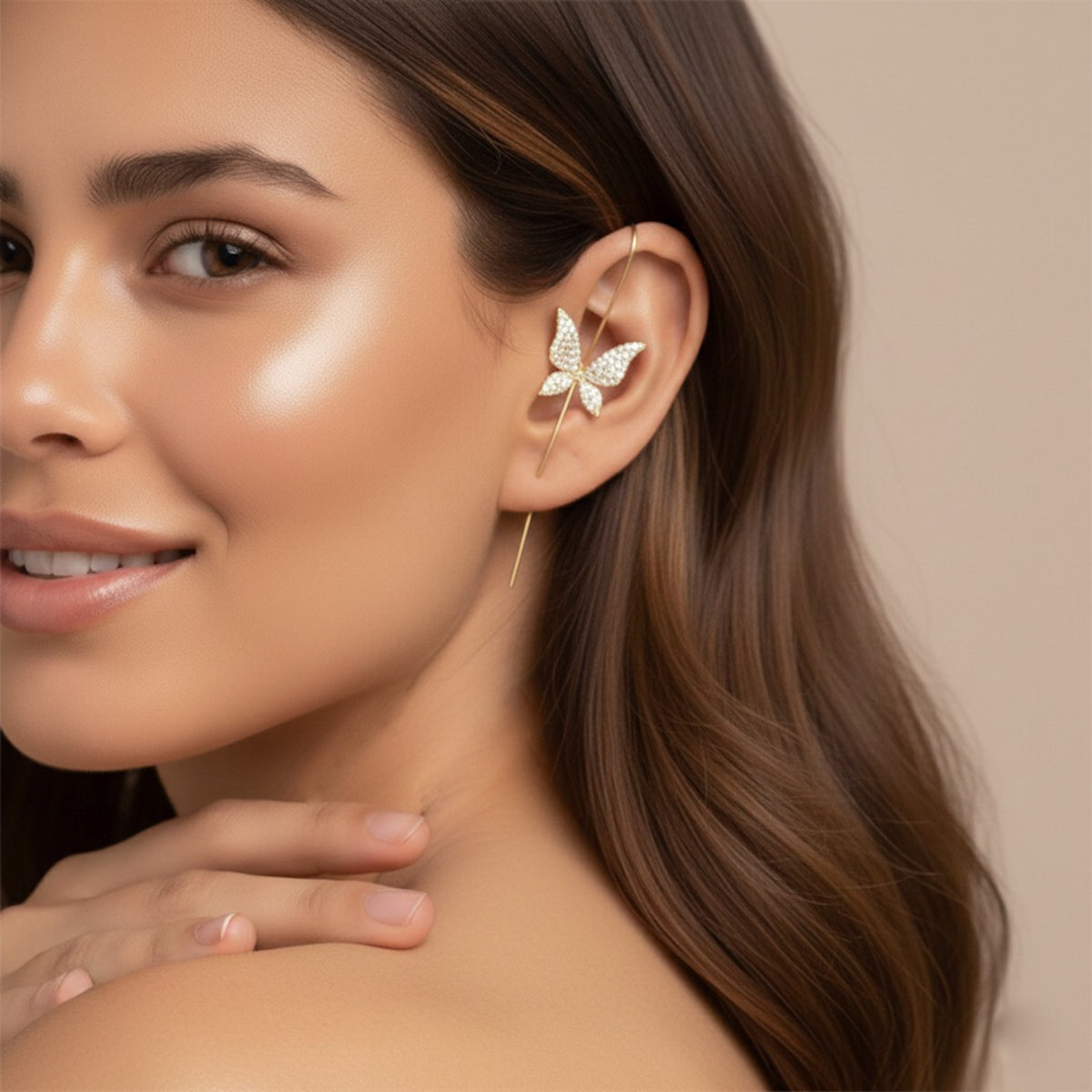 Woman wearing a delicate leaf-shaped  or butterfly shaped ear cuff ear stick ear hook earring with a neutral background