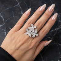 Hand wearing a decorative silver ring on a dark marble background  Mariposa Pave Statement Ring - The Songbird Collection