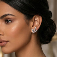Close-up of a woman wearing butterfly earrings with a blurred background