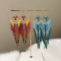 Pair of beaded earrings on a gold stand against a neutral background - Mojave Ombre Beaded Statement Earrings