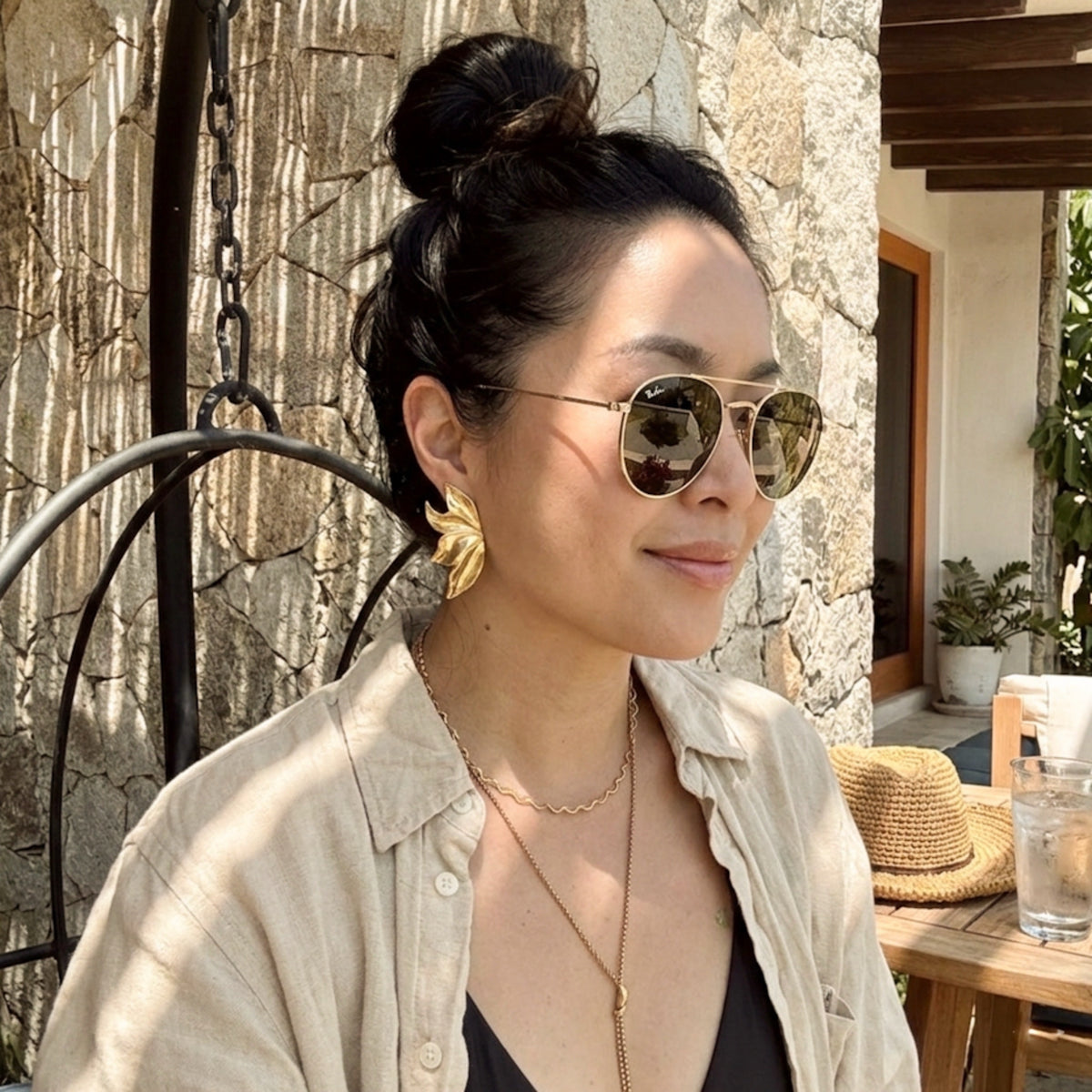 Woman wearing sunglasses and a beige shirt outdoors.  Molten Flame Statement Earrings - The Songbird Collection