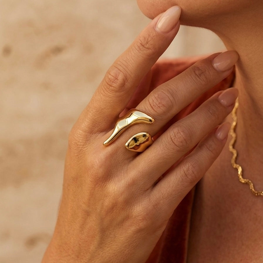 Gold ring on a hand with a blurred background. Molten Gold Statement Ring - The Songbird Collection
