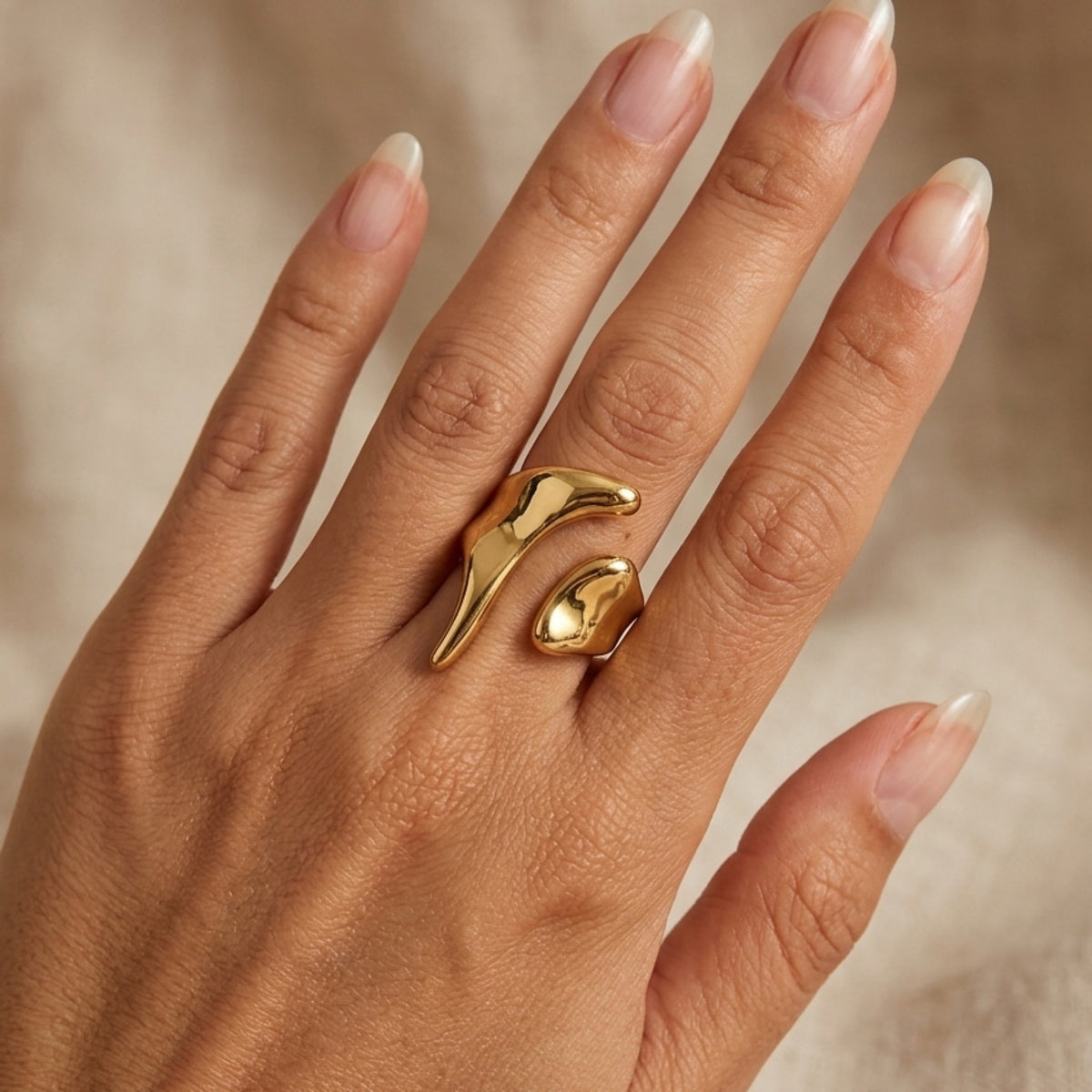 Gold ring on a hand with a neutral background. Molten Gold Statement Ring - The Songbird Collection