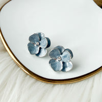 blue flower-shaped earrings with silver trimming on a white dish with gold rim - Moonlit Peony Earrings - The Songbird Collection