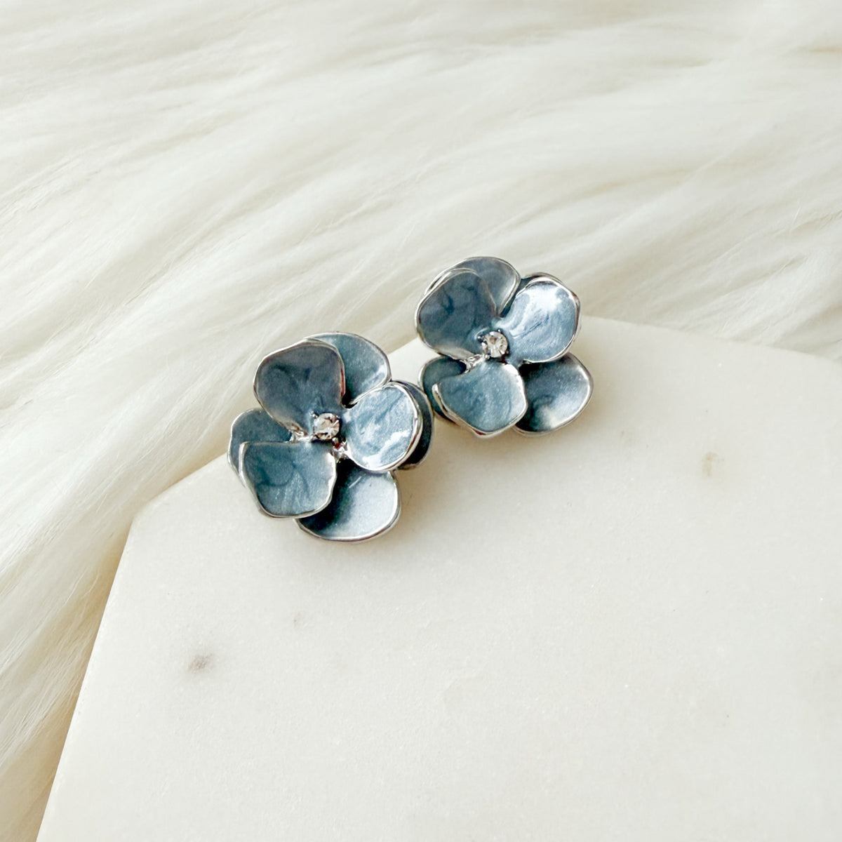 blue flower-shaped earrings with silver trimming on a white dish with gold rim - Moonlit Peony Earrings - The Songbird Collection