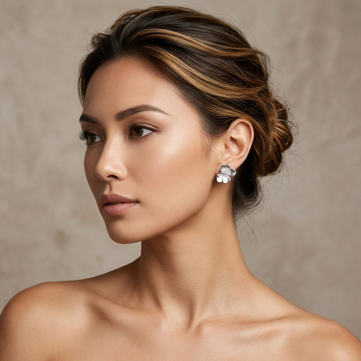 Woman wearing diamond earrings against a neutral background