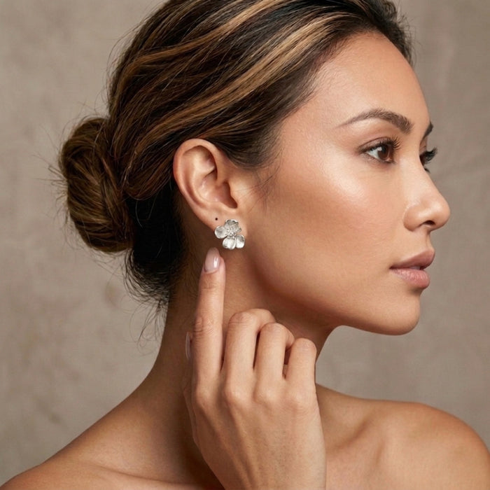 Woman wearing a floral earring against a neutral background