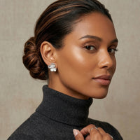 Woman wearing a dark gray turtleneck sweater with a neutral background