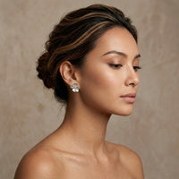 Woman wearing silver earrings against a neutral background - 