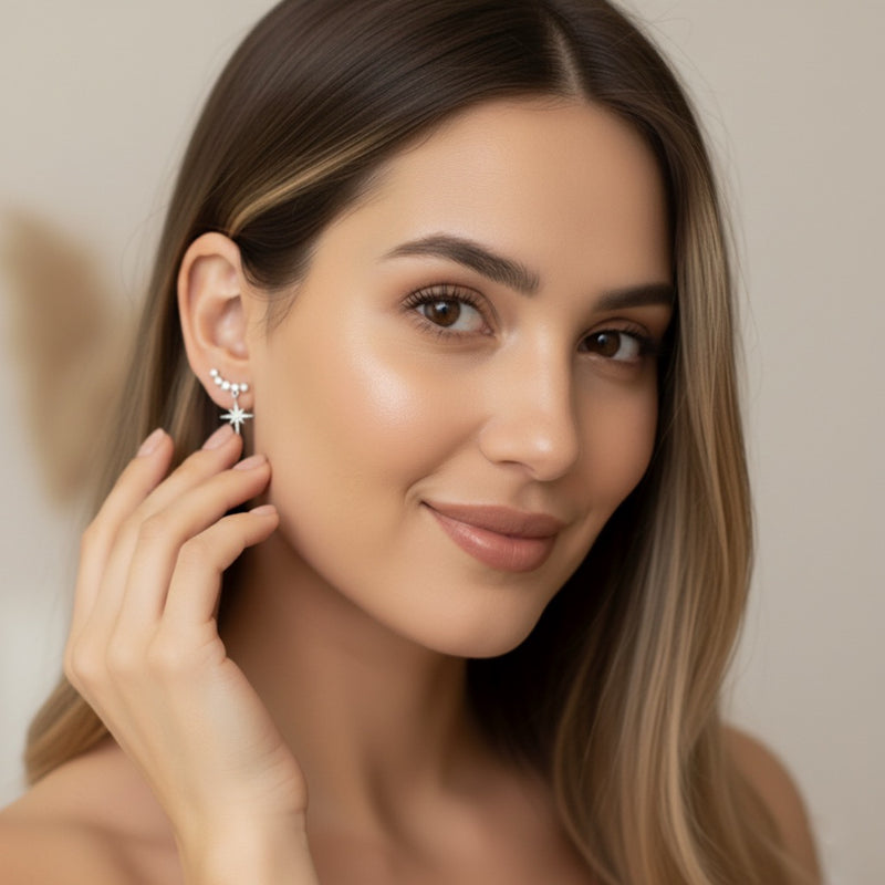 Woman wearing star-shaped earrings with a neutral background