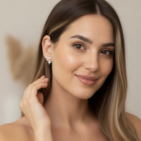 Woman wearing a star-shaped earring against a neutral background