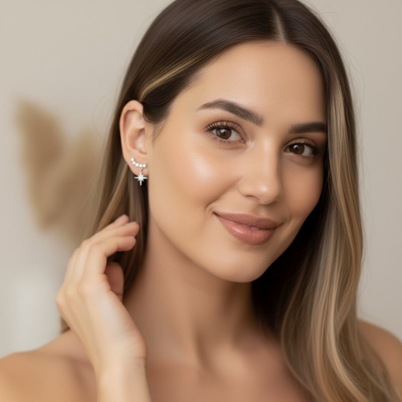 Woman wearing a star-shaped earring against a neutral background