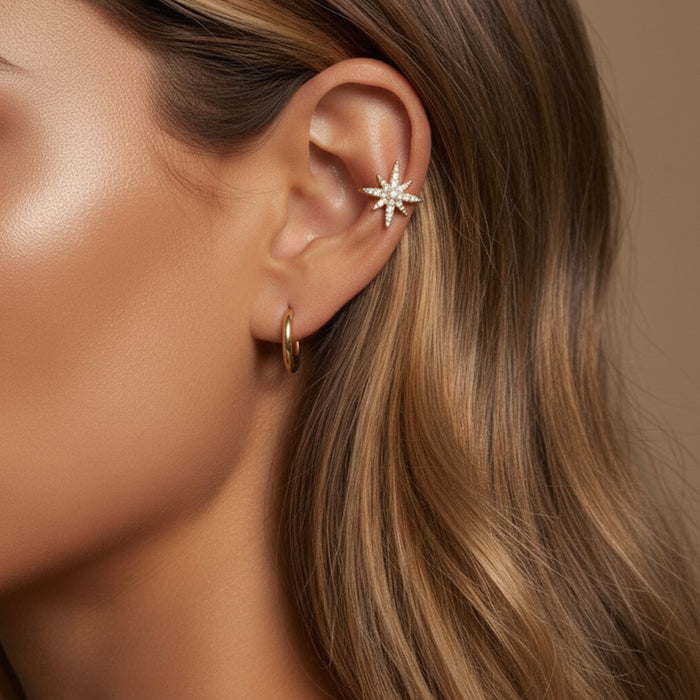 Close-up of an ear wearing a star-shaped earring with a blurred background