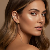 Close-up of a woman wearing star-shaped ear cuff with a neutral background